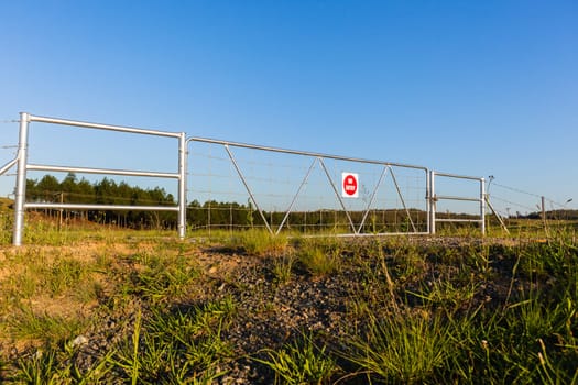 Rural farm gate fence closeup  in mountain summer blue landscape