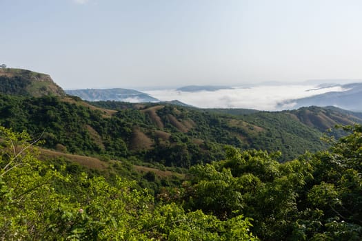 Overlooking rural valley with summer cloud mist over the tribal homes landscape.