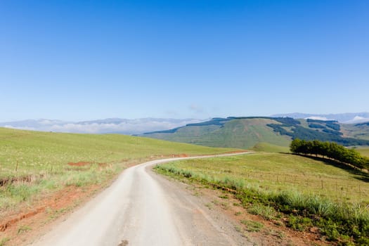Mountains dirt road route through scenic rural mountain farming terrain summer landscape.