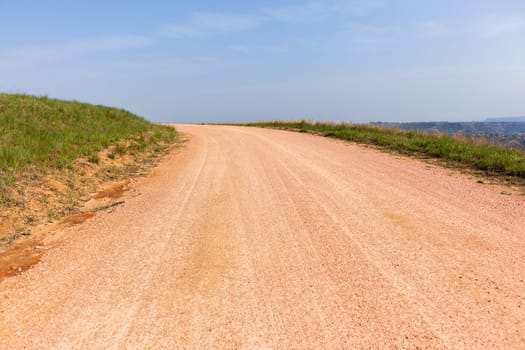 Dirt gravel road route on hillside sky rural countryside landscape