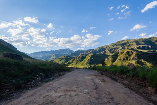 Mountains dirt road route through scenic rural mountain farming terrain summer landscape.