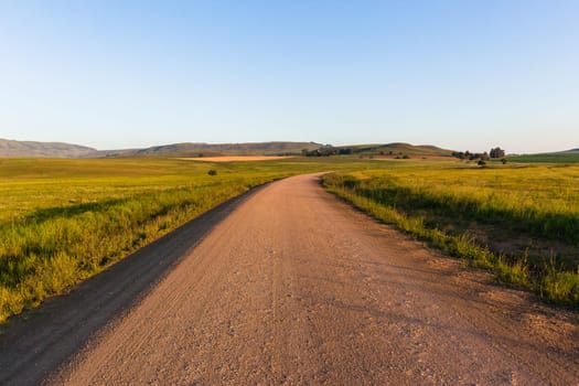 Mountains dirt road route through scenic rural mountain farming terrain summer landscape.
