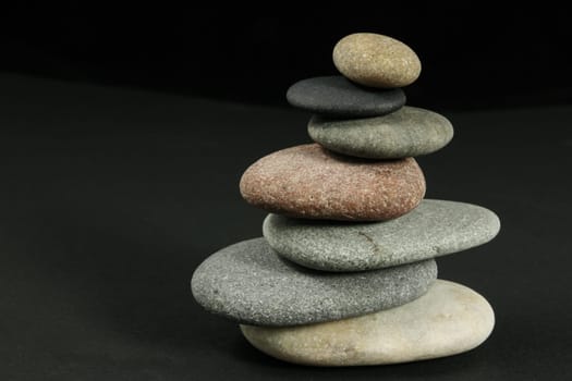 Seven pebbles pyramid in staggered rows, over dark