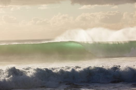 Ocean waves crashing water power towards beach from weather storms.