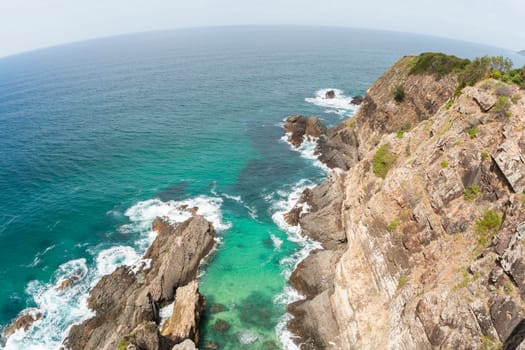 Ocean blue waters below high elevation overlooking rocky cliffs landscape