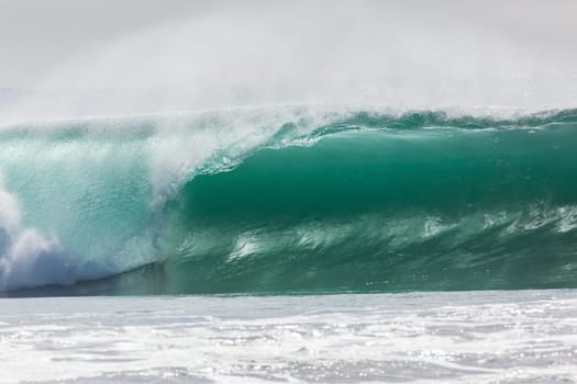 Ocean large waves crashing water power towards beach from weather storms.