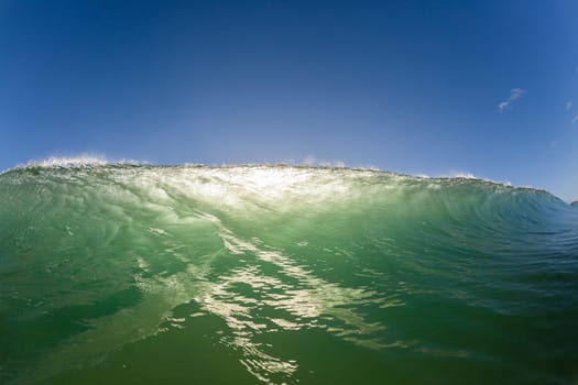 Wave ocean swimming encounter wall of water crashing breaking beauty nature power back-light closeup photo. .