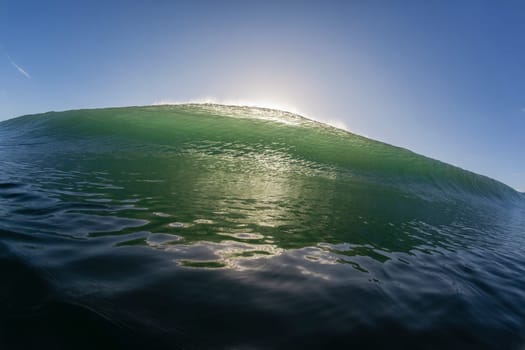 Wave ocean swimming encounter wall of water crashing breaking beauty nature power back-light closeup photo. .