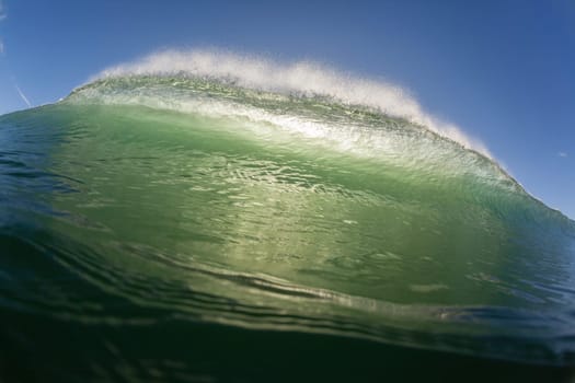 Wave ocean swimming encounter wall of water crashing breaking beauty nature power back-light closeup photo. .