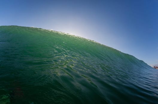 Wave ocean swimming encounter wall of water crashing breaking beauty nature power back-light closeup photo. .