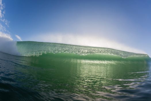 Wave ocean swimming encounter wall of water crashing breaking beauty nature power back-light closeup photo. .