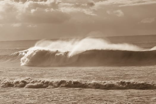 Ocean Waves crashing water power along beach rocky coastline from storm weather.