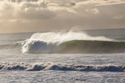 Ocean Waves crashing water power along beach rocky coastline from storm weather.