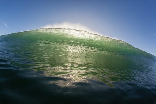 Wave ocean swimming encounter wall of water crashing breaking beauty nature power back-light closeup photo. .