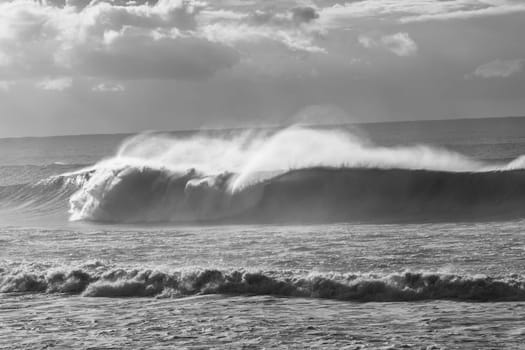 Ocean Waves crashing water power along beach rocky coastline from storm weather.