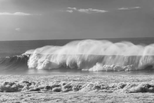 Ocean Waves crashing water power along beach rocky coastline from storm weather.