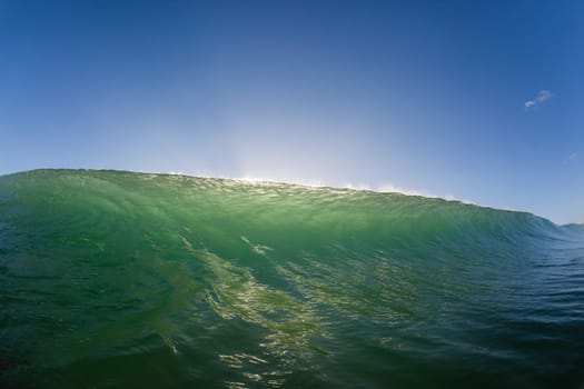 Wave ocean swimming encounter wall of water crashing breaking beauty nature power back-light closeup photo. .