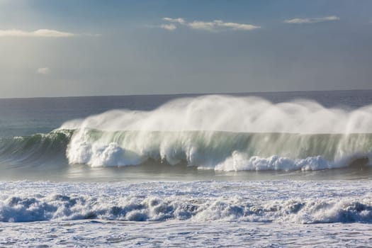 Ocean Waves crashing water power along beach rocky coastline from storm weather.