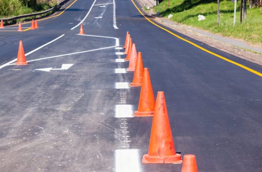 Road painting lines on new on asphalt surface with orange markers safety for vehicle traffic.