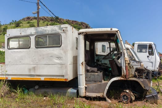 Trucks vehicles abandoned scrapped destroyed outdoors countryside.