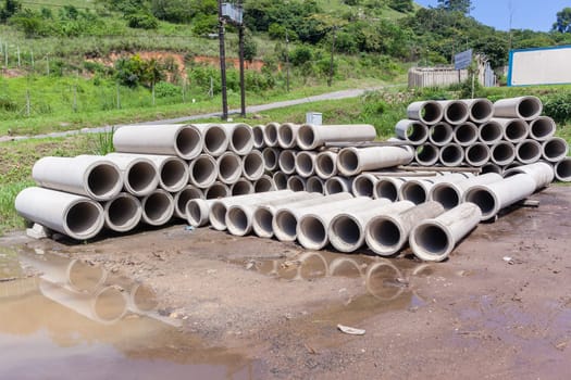 New manufactured concrete pipes stacked factory products for infrastructure industrial construction.