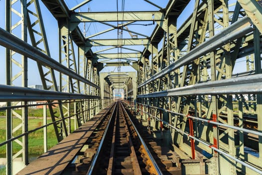 Railway bridge closeup steel tracks structure river crossing city countryside route.