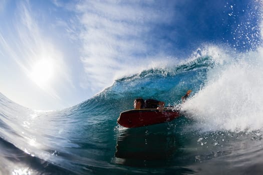 Surfing surfer body-boarder rides inside hollow ocean wave water action photo.