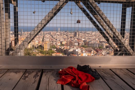 Sweatshirt and shoes of a girl who could have committed suicide by jumping off a bridge, concept stop teenage suicide, the city of Barcelona in the background