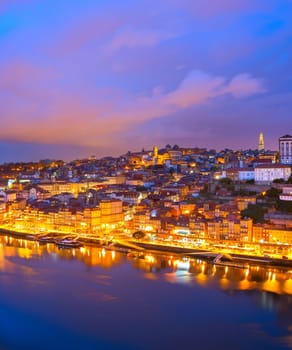 Colorful afterglow view of Porto illuminated old town with clouds, reflecting in Douro river, Portugal