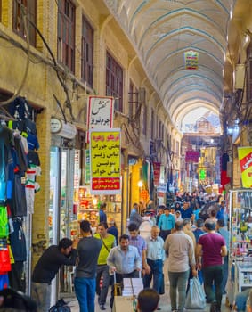 TEHRAN, IRAN - MAY 22, 2017: People walking in Tehran Grand Bazaar crowded rows by counters with colorful goods