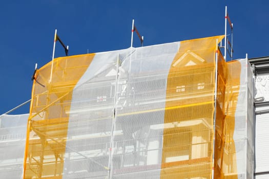 Orange-white tarpaulin, gable, scaffolding, construction site, house facade, old building, Germany, Europe