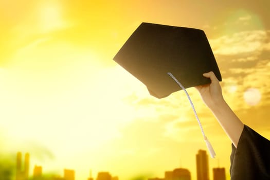 Hand holding graduation hat with sunlight background. Graduation concept