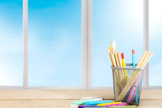 Pencils in basket container and colorful crayons on the wooden table. Back to School concept