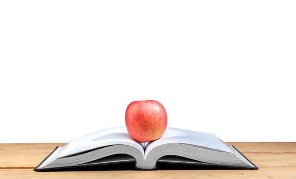 Apple on the middle of opened book on wooden table isolated over white background. Back to School concept