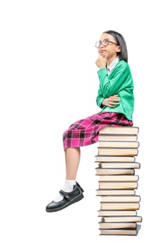 Asian cute girl with glasses think while sitting on the pile of books isolated over white background. Back to School concept