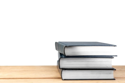 Pile of books on wooden table isolated over white background. Back to School concept