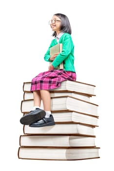 Asian cute girl with glasses holding the book while sitting on the pile of books isolated over white background. Back to School concept