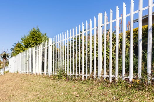 Fence steel white boundary structure closeup on boundary of  property.