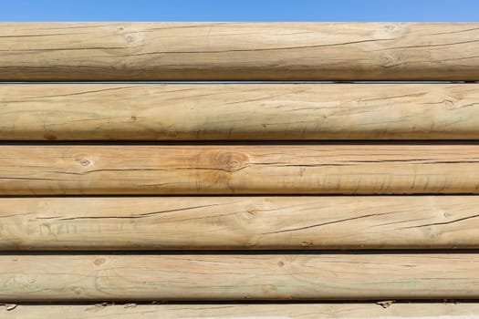 Wood poles low boundary fence wall decor outdoors closeup photo against blue sky