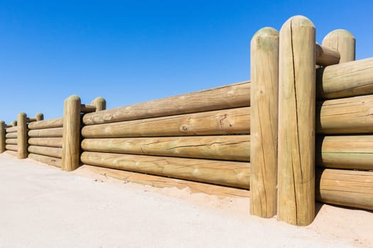 Wood poles low boundary fence wall decor outdoors closeup photo against blue sky