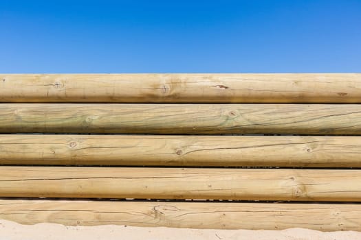 Wood poles low boundary fence wall decor outdoors closeup photo against blue sky