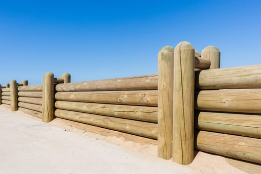 Wood poles low boundary fence wall decor outdoors closeup photo against blue sky