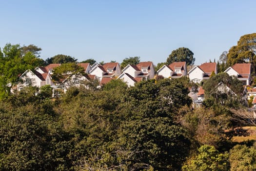 Homes houses cluster close living gated community in countryside with tree flora landscape..