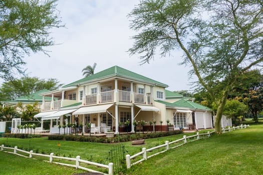 Houses homes surrounded green tropical landscaping trees vegetation on gated golf course..