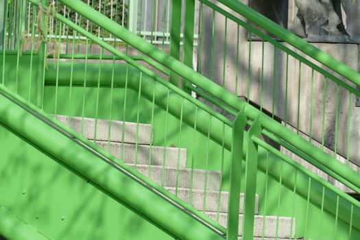 Concrete staircase and green stair railing