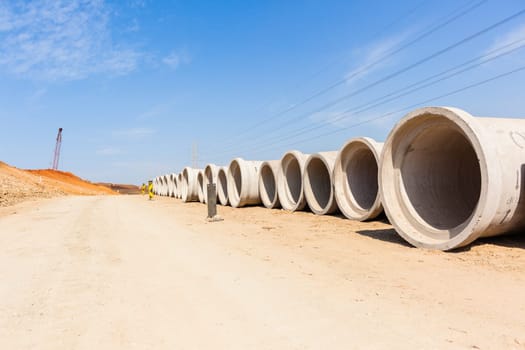 Construction new road infrastructure project development build concrete pipes earthworks industrial machines  countryside.