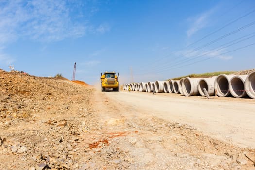 Construction new road infrastructure project development build concrete pipes earthworks industrial machines  countryside.