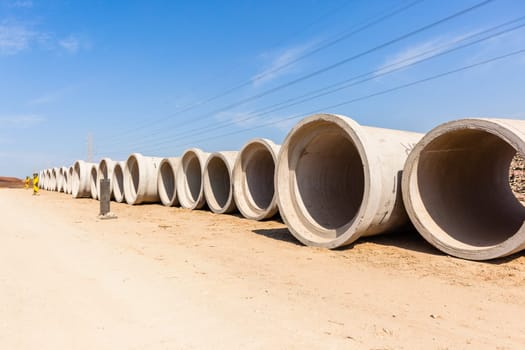 Construction new road infrastructure project development build concrete pipes earthworks industrial machines  countryside.