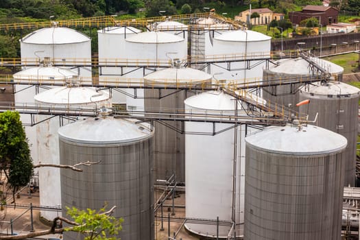 Storage steel industrial liquids oils tanks depot for fuels chemicals overlooking structures.