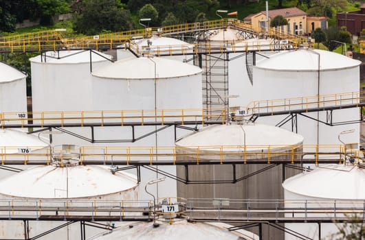 Storage steel industrial liquids oils tanks depot for fuels chemicals overlooking structures.